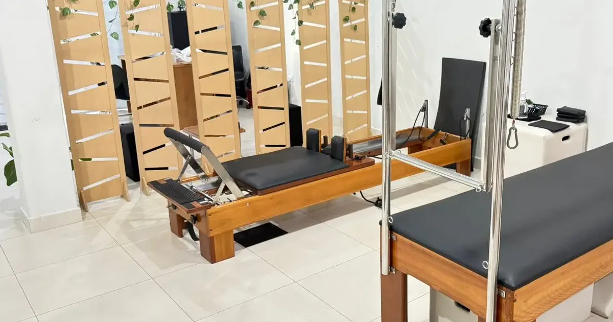 Aparelho reformer de pilates, com carrinho estofado, barra de pés e estrutura de madeira, no estúdio da Dra. Geovana Kohut em Campo Mourão