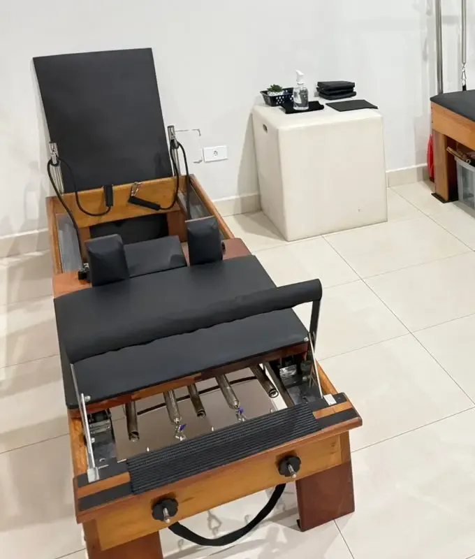 Reformer visto de frente, com a barra de pés, as molas presas ao carrinho e as ombreiras, no estúdio em Campo Mourão