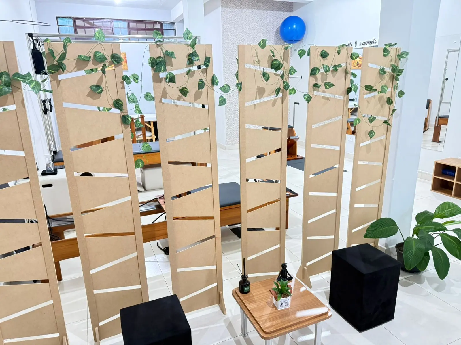 Biombos de madeira com plantas naturais — ambiente acolhedor do estúdio