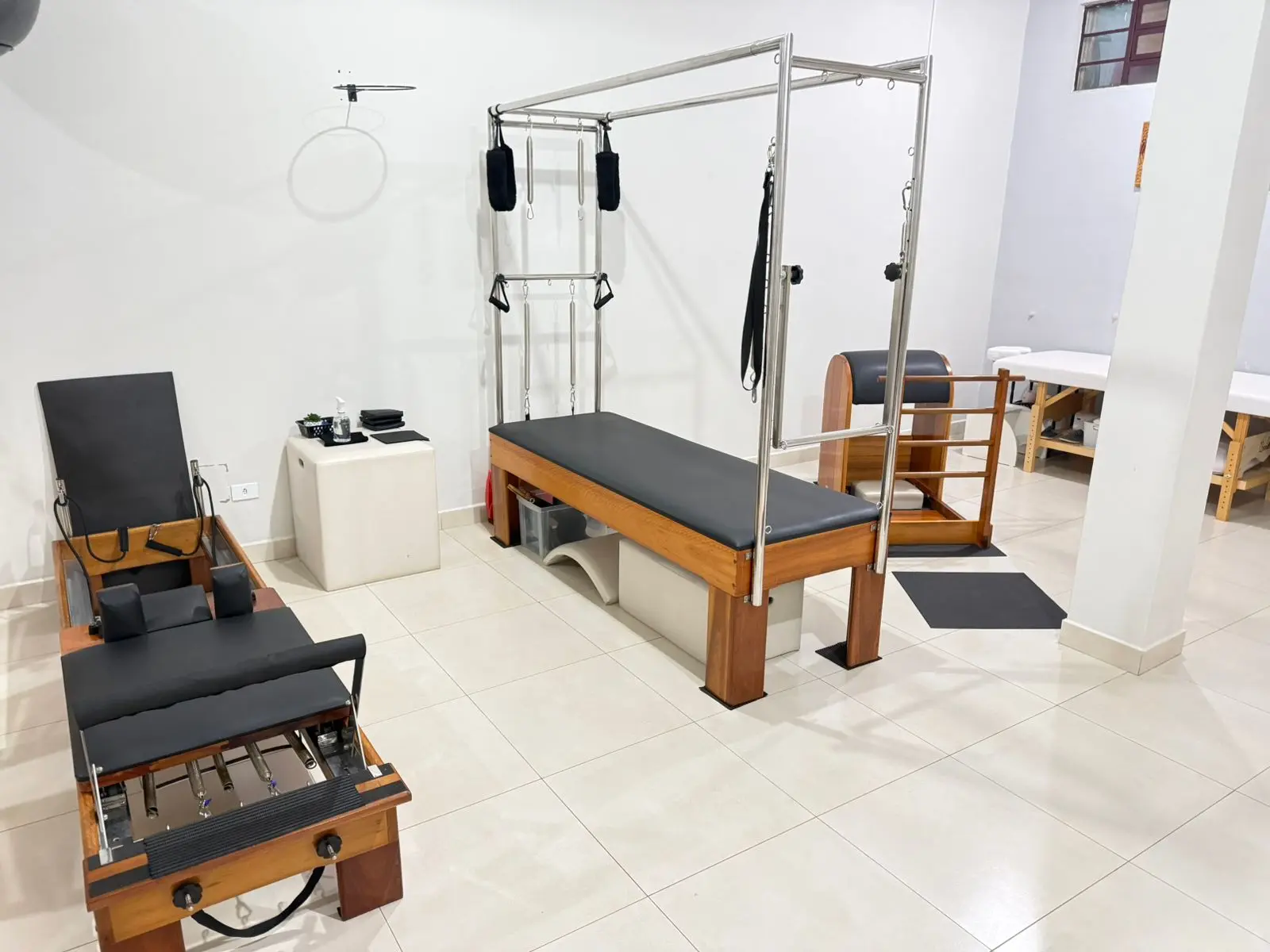 Vista geral da sala com Cadillac, Reformer e maca de fisioterapia